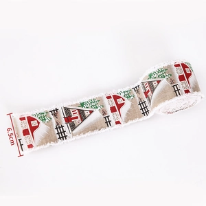 Detail of 6.5cm linen Christmas ribbon featuring rustic barn and snowy pine tree patterns