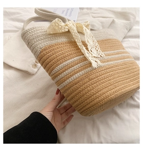 Détail du sac de plage en paille fait main avec nœud en dentelle blanche élégante