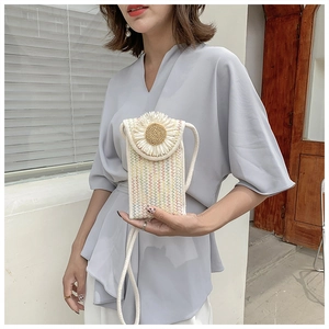 Detail of handmade woven crossbody bag with sunflower flap and long strap
