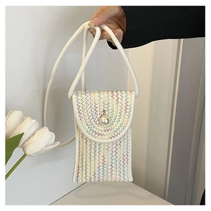 Detailed macro of handwoven mini bag with colorful wavy embroidery and large pearl clasp