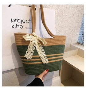 Détail du sac cabas tissé avec rayures vertes et nœud décoratif en dentelle vintage