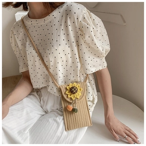 Detail of woven khaki straw phone bag with yellow sunflower and thin shoulder strap