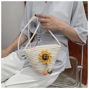 Close-up of woven straw bucket bag with sunflower applique and rainbow zigzag stripes