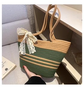 Détail d'un sac de plage tissé main à rayures vertes avec un nœud en dentelle blanche