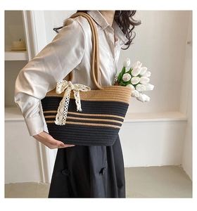 Détail du sac cabas tissé main avec rayures noires et nœud décoratif en dentelle blanche