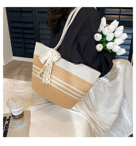 Détail du sac de plage tissé à la main avec nœud en dentelle et design color-block chic
