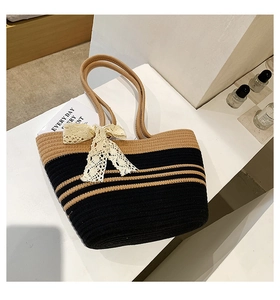 Détail du sac de plage tissé à rayures avec un nœud décoratif en dentelle élégant