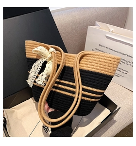 Détail du sac de plage tissé à rayures noires avec un nœud en dentelle élégant