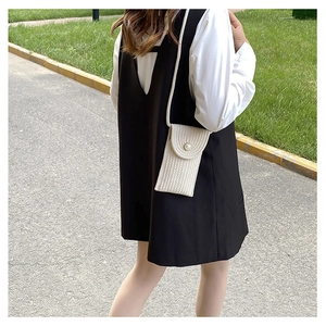 Close-up of white woven mini crossbody bag with pearl button detail on outdoor model
