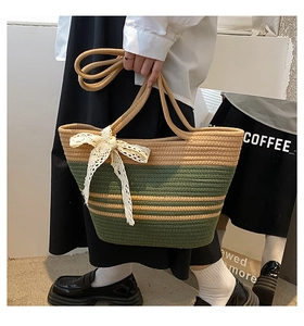 Détail du sac de plage tressé à rayures beige et vert avec nœud en dentelle blanche