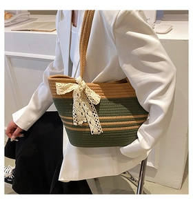 Détail du sac de plage tressé vert et marron avec un nœud décoratif en dentelle blanche