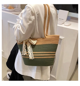 Détail du sac de plage rayé tissé main avec un nœud décoratif en dentelle blanche