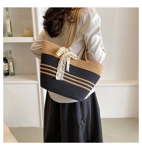 Détail du sac de plage tissé à rayures avec nœud en dentelle blanche et texture naturelle