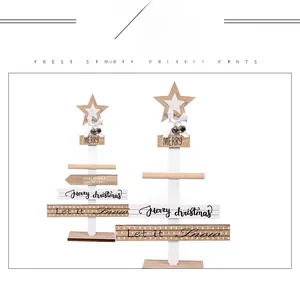 Close-up of DIY wooden Christmas tree signs with star toppers and ribbon bells