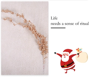 Detail of golden champagne berry stems for Christmas decor on white faux fur background