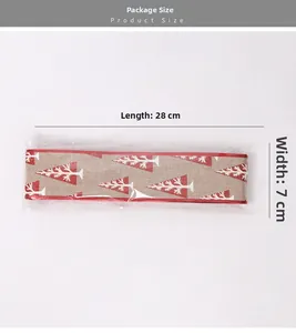 Detail of 10m burlap Christmas ribbon with red edges and printed pine tree patterns
