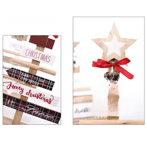 Detail of wooden DIY Christmas tree tabletop ornament with red bows and bell