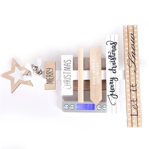 Close-up of rustic wooden Christmas tree wall hanging on scale weighing 103.3g