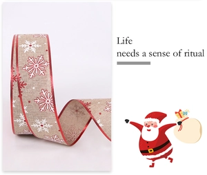 Detail of Christmas faux linen ribbon with white snowflake prints and red metallic edges