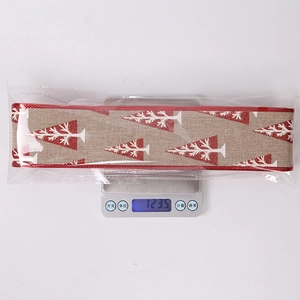 Detail of 10m faux burlap Christmas ribbon roll with red glitter trees and sewn edges