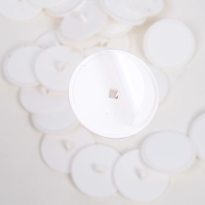 Macro shot of white circular ceiling hooks with square center holes for festive banners