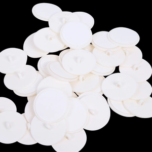 Macro detail of white plastic ceiling hooks showing the circular base and hanging loop