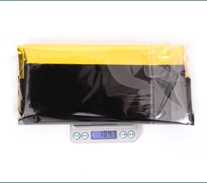 Weight measurement of 104.7g for the gold and black PET tablecloth in packaging