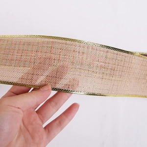 Détail du ruban de Noël en maille dorée semi-transparente avec des bordures jacquard