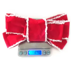 Detailed close-up of a festive red velvet Christmas bow with white plush edging detail