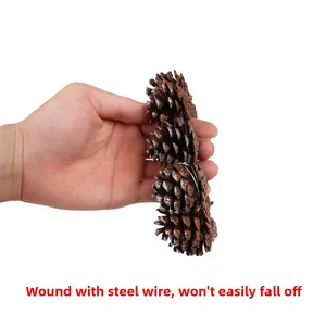 Detail of natural pine cones hand-held for Christmas garland decoration and festive layout