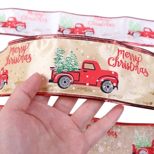 Detailed texture of champagne gold Merry Christmas ribbon with vintage red truck print