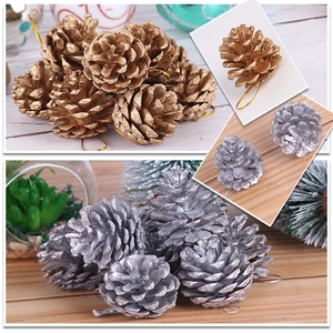 Close-up of gold and silver Christmas pine cones with hanging strings for DIY decor
