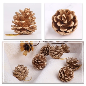 Close-up of golden Christmas pine cones with hanging strings for tree decoration