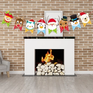 Close-up of colorful Christmas cartoon bunting flags hanging above a cozy fireplace mantle