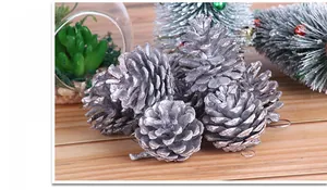 Close-up of silver-painted Christmas pine cones with hanging loops for tree decoration