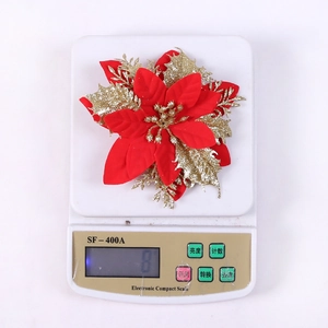 Detail shot of 14cm red velvet glitter Christmas flower showing 8g weight on scale