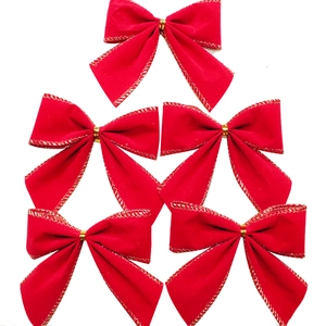 Detail of red velvet Christmas bows with gold edges and metallic ties for festive decor