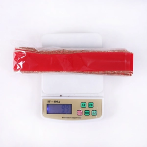 Close-up of 10m red velvet Christmas ribbon with gold edges in protective plastic film wrap