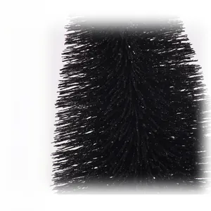 Macro detail of black frosted pine needles with delicate white powder and glitter texture