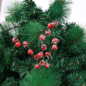 Macro shot of artificial red berries with realistic snow dust on green pine branches