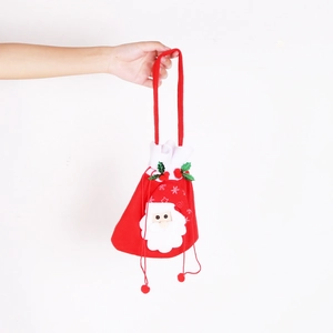 Detail of Christmas Santa drawstring gift bag with plush pom-poms and soft festive fabric