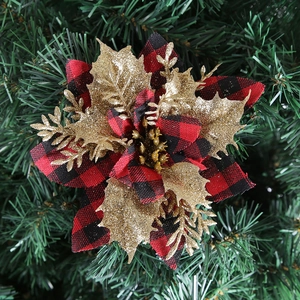 Macro shot of red and black buffalo plaid Christmas poinsettia with gold glitter leaves