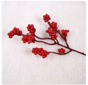Close-up of vibrant red artificial berry branch with lifelike brown stem for holiday decor