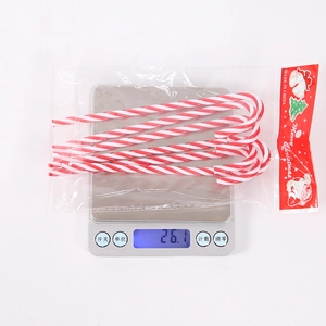 Detail view of 6-piece red and white candy cane ornaments in packaging with weight scale