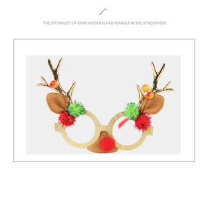 Detail of Christmas reindeer glasses with golden antlers, plush ears and colorful pom-poms