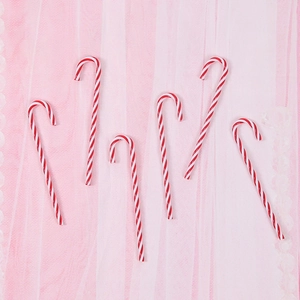 Set of six red and white candy cane Christmas tree hanging ornaments on pink background