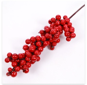 Detailed view of vibrant artificial red berries with glossy finish on a dark brown stem