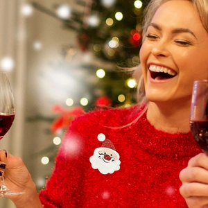 Broche Père Noël en intissé avec bonnet scintillant sur un pull rouge pour les fêtes