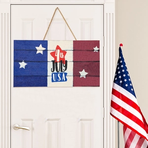 Detail view of a 4th of July wooden plaque featuring American flag patterns on a white door
