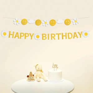 Vue macro de la bannière d'anniversaire jaune en feutre avec marguerites et sourires